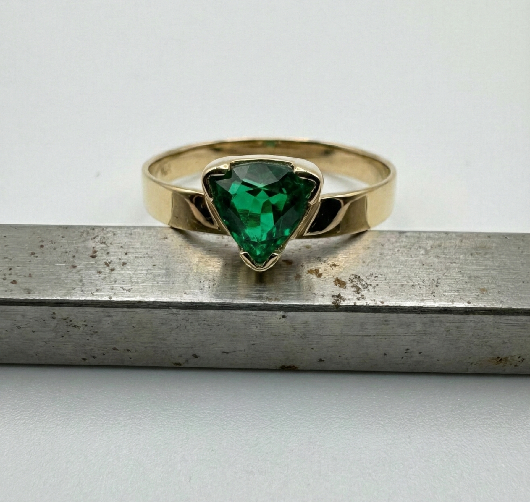 Trillion cut emerald ring in 14k gold