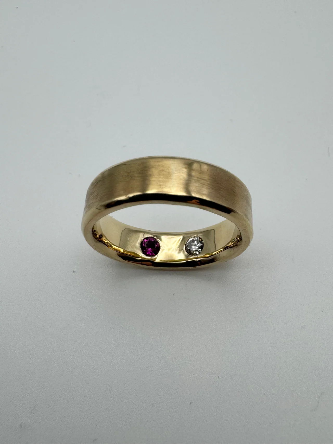 Gold band with hidden diamond and ruby set inside the band